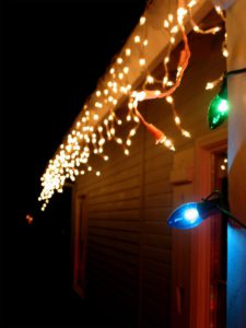 hanging holiday decorations on roof and gutters